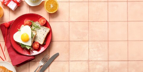 Plate with tasty heart-shaped fried egg, toasts, tomatoes and arugula on beige tile background with space for text