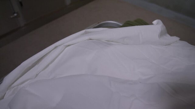 A corpse on a gurney in a hospital morgue