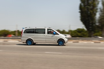 Fototapeta premium Car driving on road at high speed with moving background.