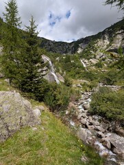 Clear Alpine waterfall in cloudy day