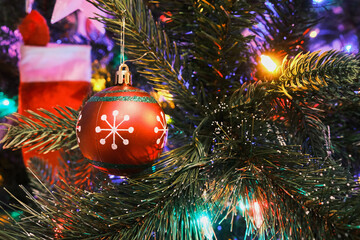 Glass ball toy on a Christmas tree with colorful lights