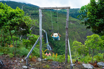 Tourists experiencing the extreme of the swing at a beautiful, enchanting waterfall