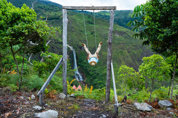 Tourists experiencing the extreme of the swing at a beautiful, enchanting waterfall