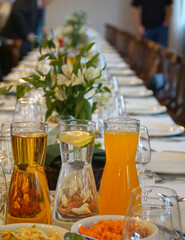 Elegant table arrangement in a restaurant for a banquet, dinner or wedding. Carafes of cold beverages are in the foreground. Selective Focus.