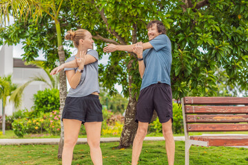 A man and woman working out together in a sunny park, staying active and motivated as a team. Outdoor fitness, wellbeing, healthy lifestyle, exercise routine and relationship bonding concept