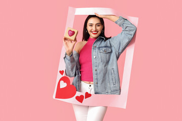 Beautiful young happy woman with gift box and frame on pink background. Valentine's Day celebration