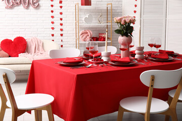 Table setting decorated for Valentine's Day with pink roses and candles at home