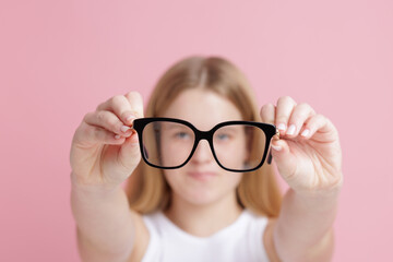 Teen girl holding glasses for poor vision and eye care