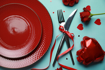 Beautiful table setting for Valentine's Day with red rose and decor on turquoise background