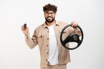 Happy man holding car key and steering wheel, concept of new car ownership