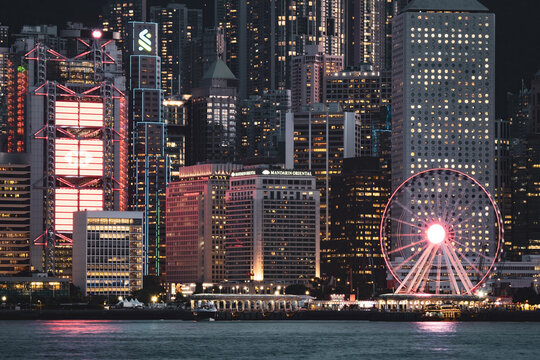 Night view of the Hong Kong Observation Wheel at Victoria Harbor in front of Hong Kong's fantastic skyline with its impressive illuminated skyscrapers