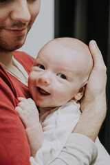 Father holding gently tiny newborn boy in his hands. Daddy showing affection to baby. Gental parenting and family love atmosphere concept. dad share a tender parenting moment 
