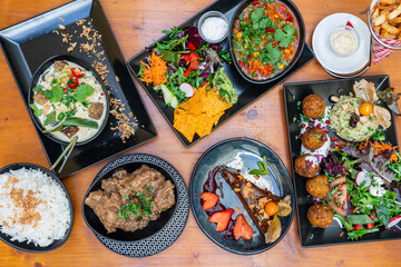 Colorful assortment of gourmet dishes arranged on wooden table, featuring fresh ingredients and vibrant presentation for culinary enthusiasts