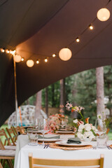 Coziness and style. Modern event design. Table setting at wedding reception. Floral compositions...