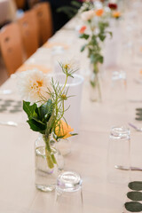 Coziness and style. Modern event design. Table setting at wedding reception. Floral compositions...