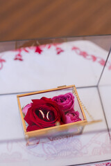 Modern wedding jewelry. Closeup of two wedding rings in a vintage box with flower petals.