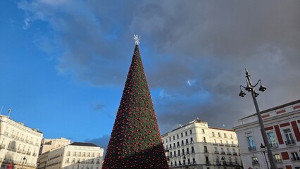 Festive Christmas tree in urban square with dramatic sky for holiday celebration