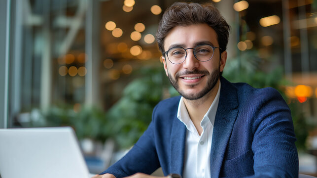 Successful Middle Eastern man using laptop at work, glass office background, confident smile, corporate portrait, with copy space