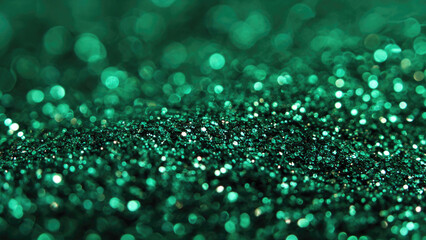 A mesmerizing close-up of emerald green glitter, shimmering with a beautiful bokeh effect. This sparkling texture creates a festive abstract background.