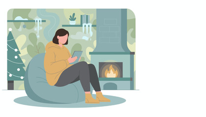 Woman relaxing indoors by fireplace with tablet on a cozy winter evening