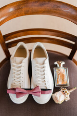 Wedding morning composition. Groom's look details of fresh boutonniere, shoes, bow tie  and perfume.