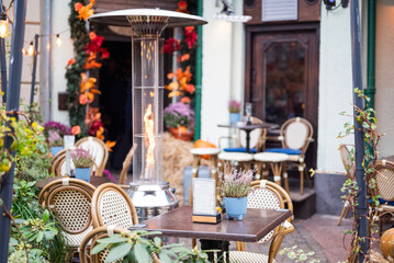 interior of a cafe restaurant on a summer terrace in autumn with a heater
