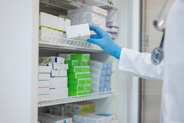 a pharmacist takes medicines in boxes from a refrigerator in a pharmacy or hospital.