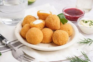 Plate with delicious fried mozzarella balls on light background, closeup