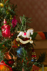 Old vintage Christmas ornament horse from Soviet childhood on branch of artificial miniature tree, selective focus