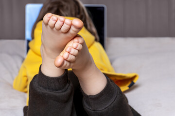 Close-up of a child's feet while watching a cartoon