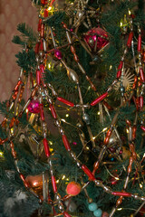 Artificial Christmas tree decorated with vintage old glass beaded necklaces in retro style, dark holiday background, selective focus