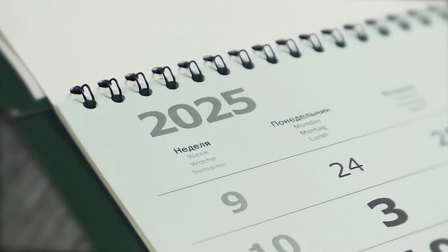 Close-up spiral paper calendar with pages turning as the date changes from 2025 to 2026, symbolizing New Year, new beginnings, fresh business opportunities and future successes