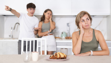 Portrait of thoughtful woman who had conflict with adult children while cooking dinner in home kitchen