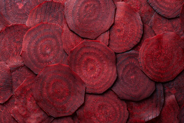 Organic red beetroot slices background. Fresh beetroot texture, closeup, top view. Heap uncooked...