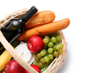 Wicker basket with tasty food and wine for picnic on white background. Top view