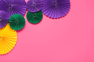 Colorful paper fans on pink background. Celebration of Mardi Gras © Pixel-Shot