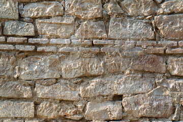 A wall made of stone with a few bricks missing