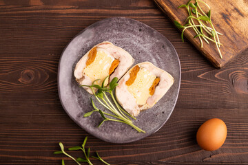 Chicken, egg and dried apricot meatloaf, microgreen on brown wooden. Diet, healthy eating. top view, close up