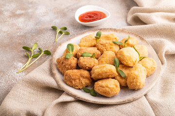 Fried crispy Chicken Nuggets with ketchup, microgreen on brown concrete. Diet, healthy eating. side view, close up