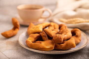 Crunchy biscuit Brushwood cookies on brown concrete, linen textile, cup of coffee, side view, selective focus