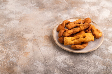 Crunchy biscuit Brushwood cookies on brown concrete, side view, copy space