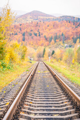 Railroad track leading into the distance. Track among autumn mountain landscapes