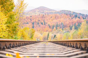Railroad track leading into the distance. Track among autumn mountain landscapes
