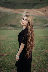 Fototapeta premium Woman With Long Wavy Hair Standing Outdoors in Natural Landscape
