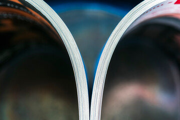 Edges of the pages of an open paper magazine or book.