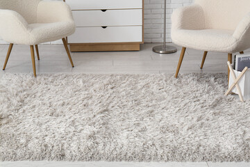 Armchairs, chest of drawers and fluffy carpet in living room