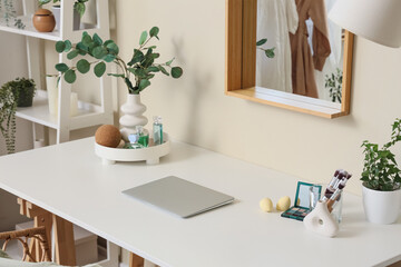 Makeup products with laptop on table in dressing room