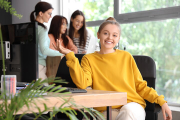 Female programmer sitting at table in office