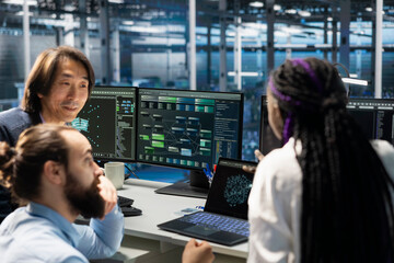 Team of engineers working in server farm with hardware supporting advanced analytics tasks and data mining. Data center teamworking colleagues doing maintenance on racks storing blockchain records