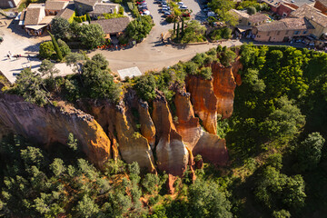 Roussillon ochre rock formations captured from above, showing stratified red terrain and walking trails